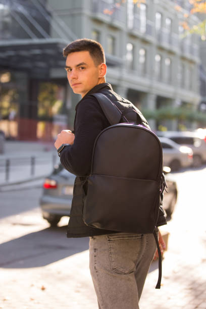 Tourist man with leather backpack in a city