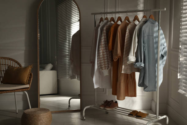 Modern dressing room interior with stylish clothes, shoes and large mirror