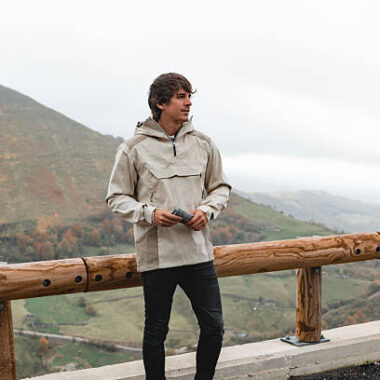 Young man standing at a scenic mountain viewpoint