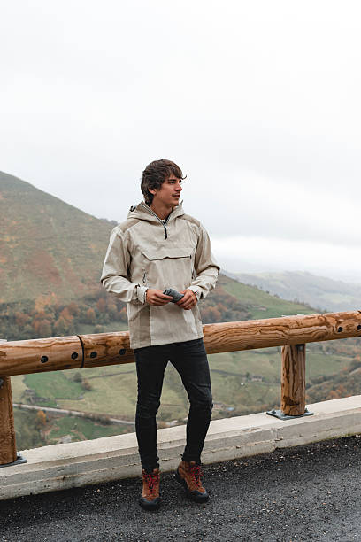 Young man standing at a scenic mountain viewpoint
